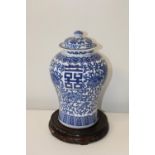 A large Chinese blue & white ginger jar with lid, on a wooden stand. 33 cm h