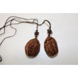 A par of carved walnut pendants
