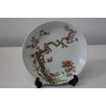 A Chinese dish, finely decorated with prunus & flowers, with character mark to base d23cm (sold as