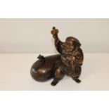 A Chinese bronzed figurine of a man with sack & mouse. 25cm x 25cm