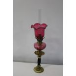 A vintage brass & cranberry glass oil lamp. Height 56cm