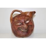 A Martin Brothers double sided face jug. Incised mark to the base reads R W Martin Bros London