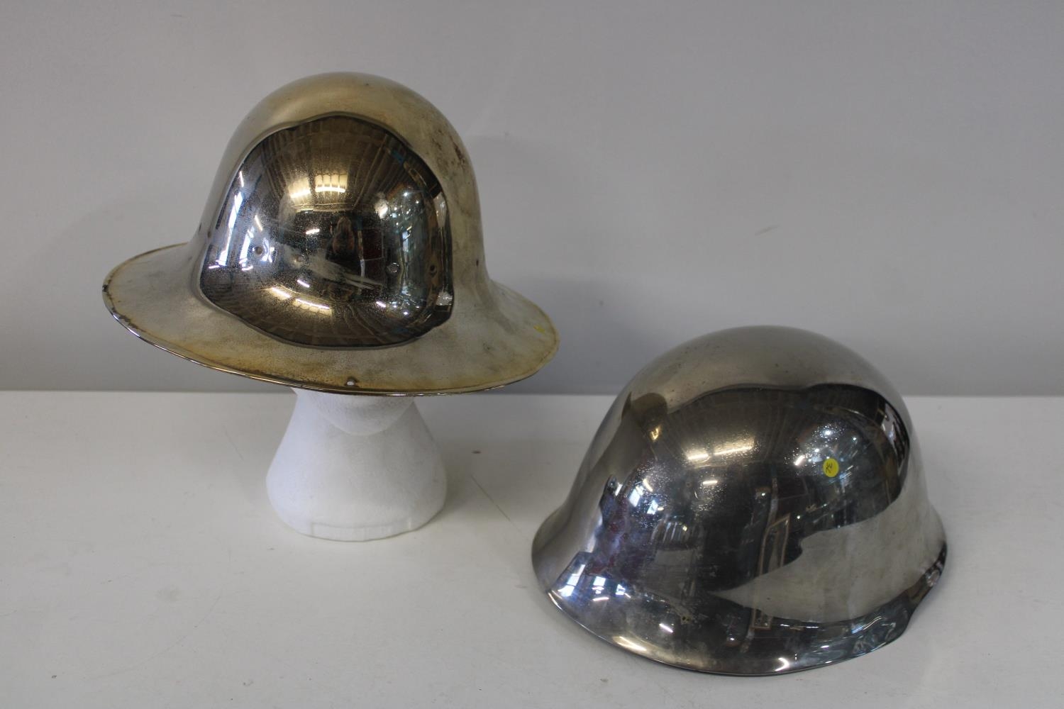 Two chromed military helmets one dated 1941