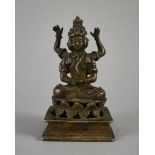 Sitzende vierarmige Gottheit mit drei Köpfen. Gelbguss. Orissa, 19. Jh. H 15 cm
