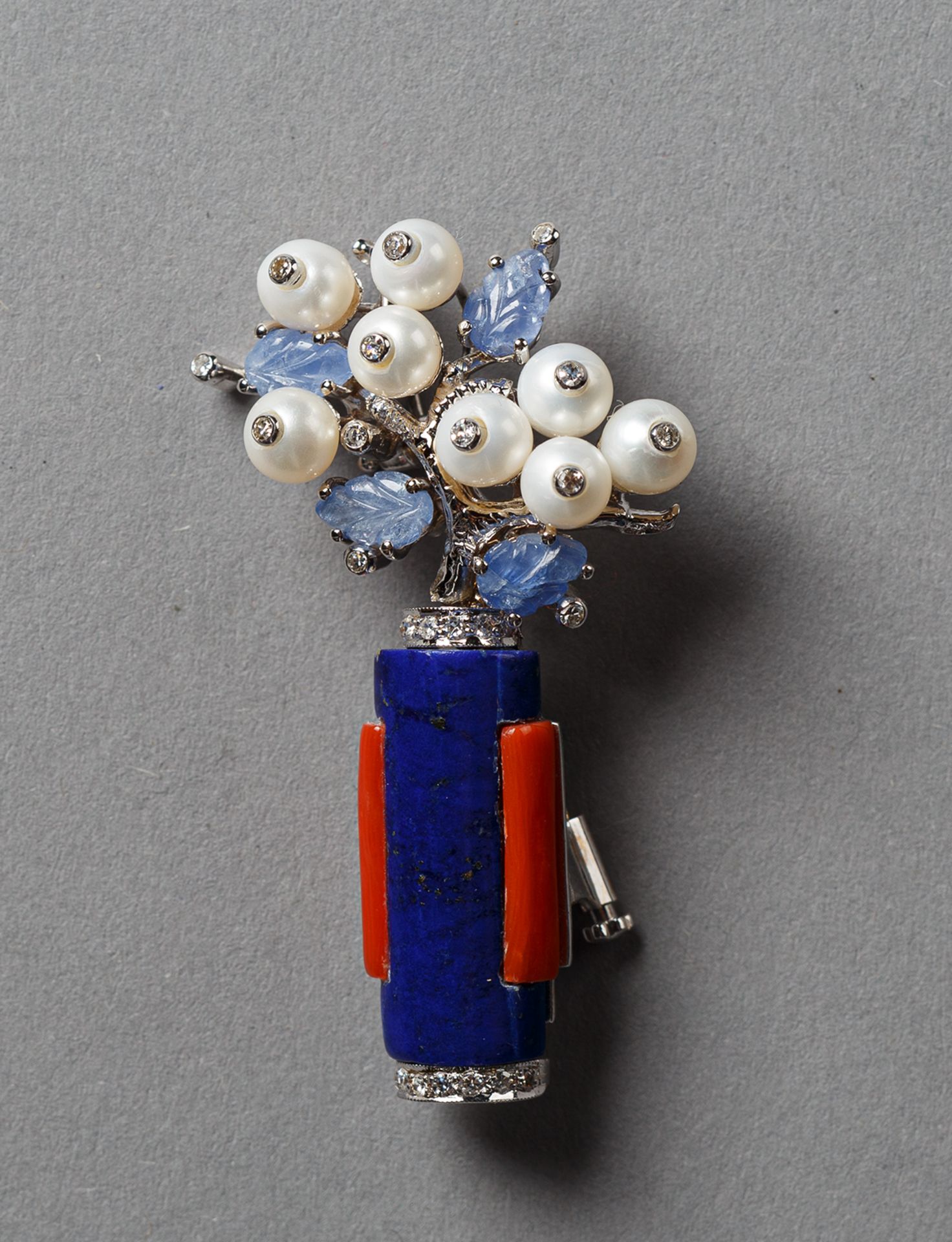 Brosche im Stil des Art Déco. Vasenform aus Lapislazuli und Koralle, Blüten aus geschnittenen
