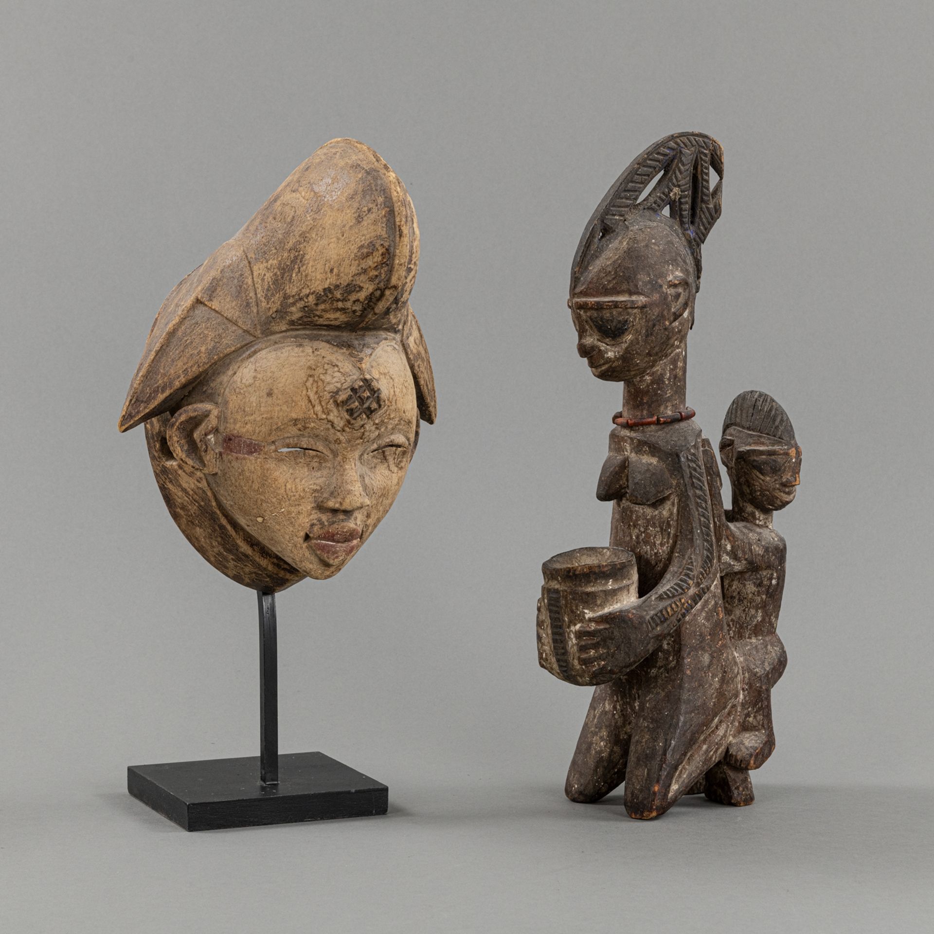 A CARVED  WOOD FIGURE OF A MOTHER WITH CHILD AND A WOOD PUNU- MASK