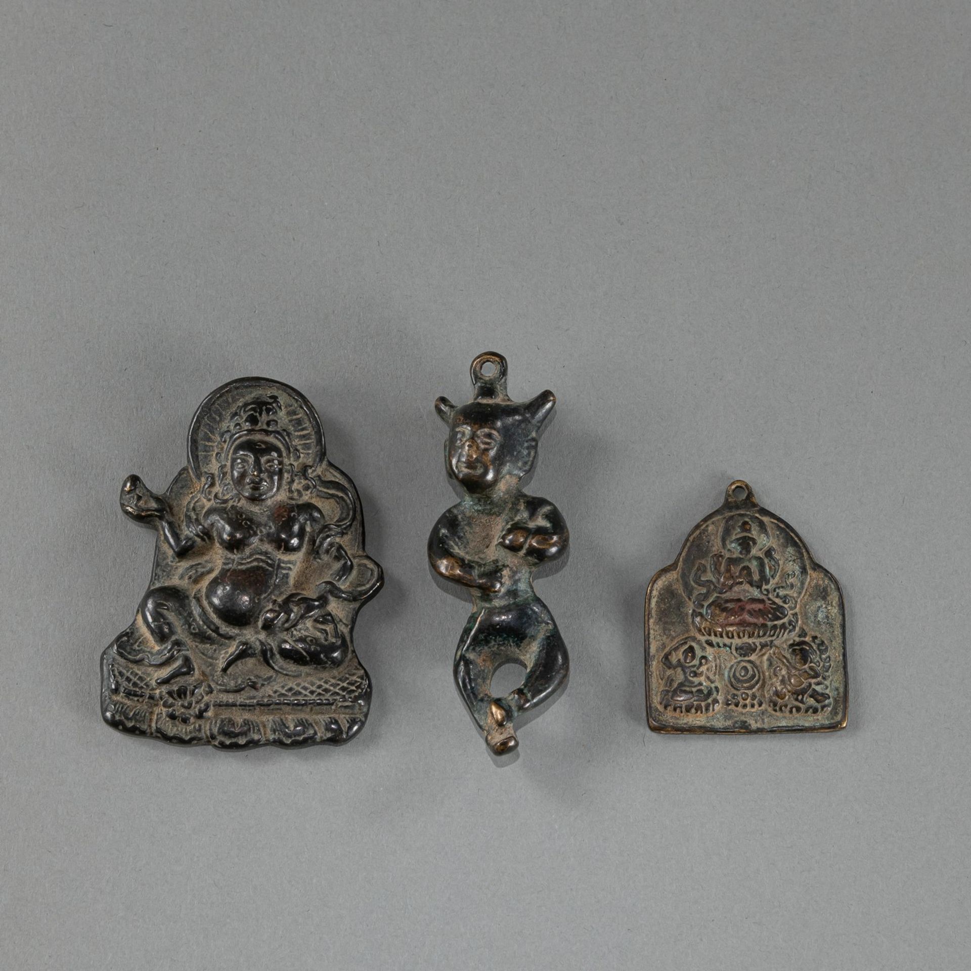 THREE SMALL BUDDHIST BRONZE PENDANTS