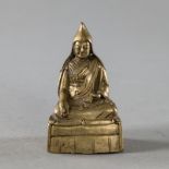 Bronze eines auf einem KIssen sitzenden Lama