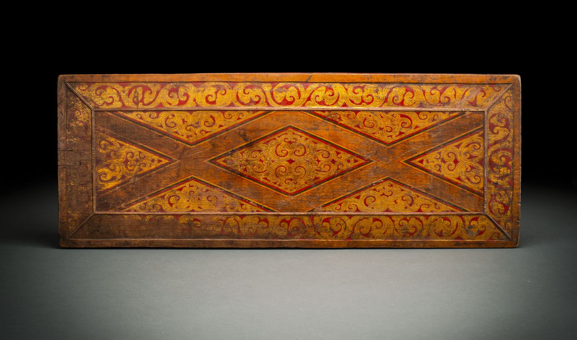 A GILT AND POLYCHROME MANUSCRIPT COVER FROM WOOD WITH LOYENGE MOTIF AND TENDRILS