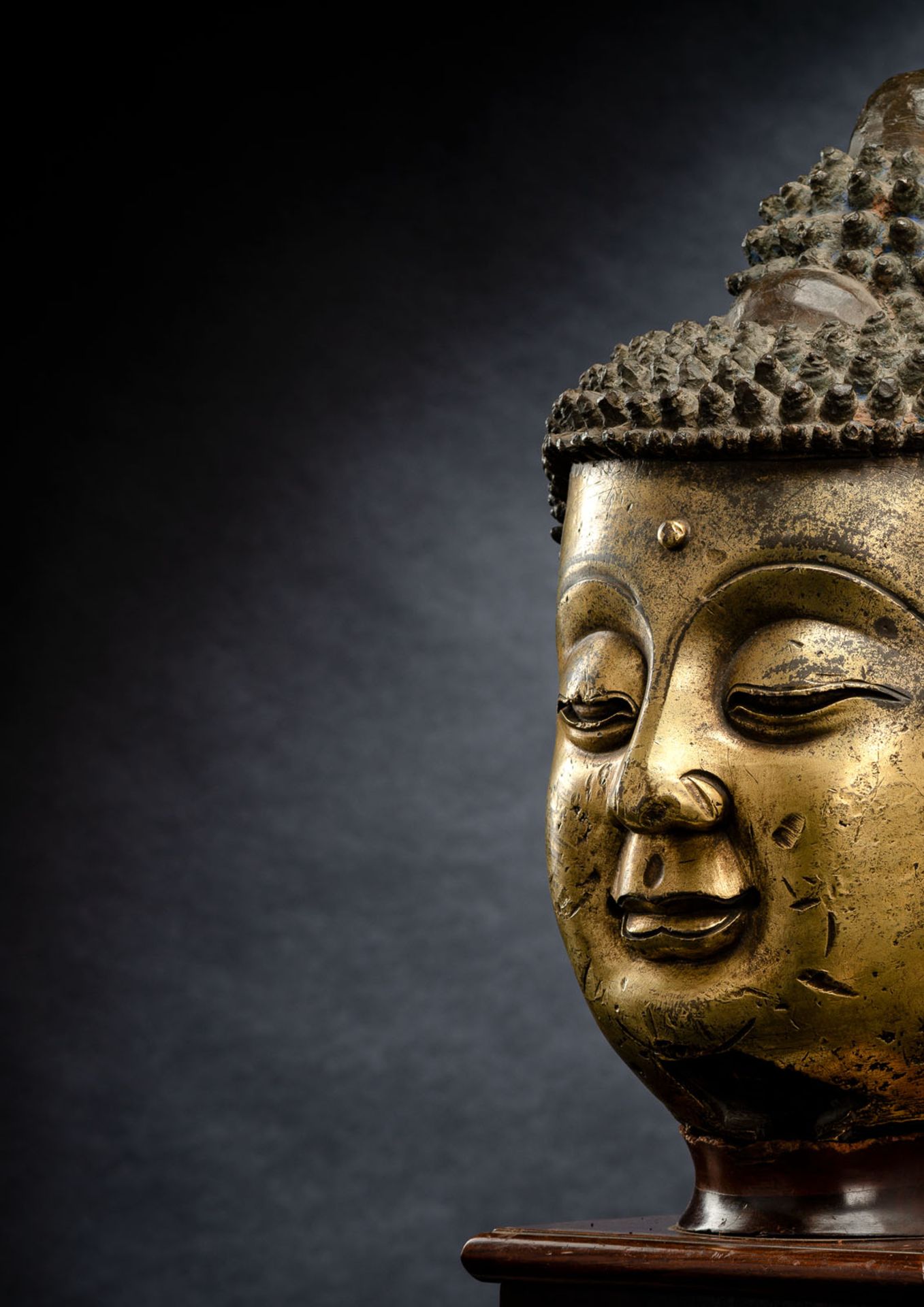 A LARGE GILT-BRONZE HEAD OF BUDDHA ON A WOOD STAND - Image 2 of 13