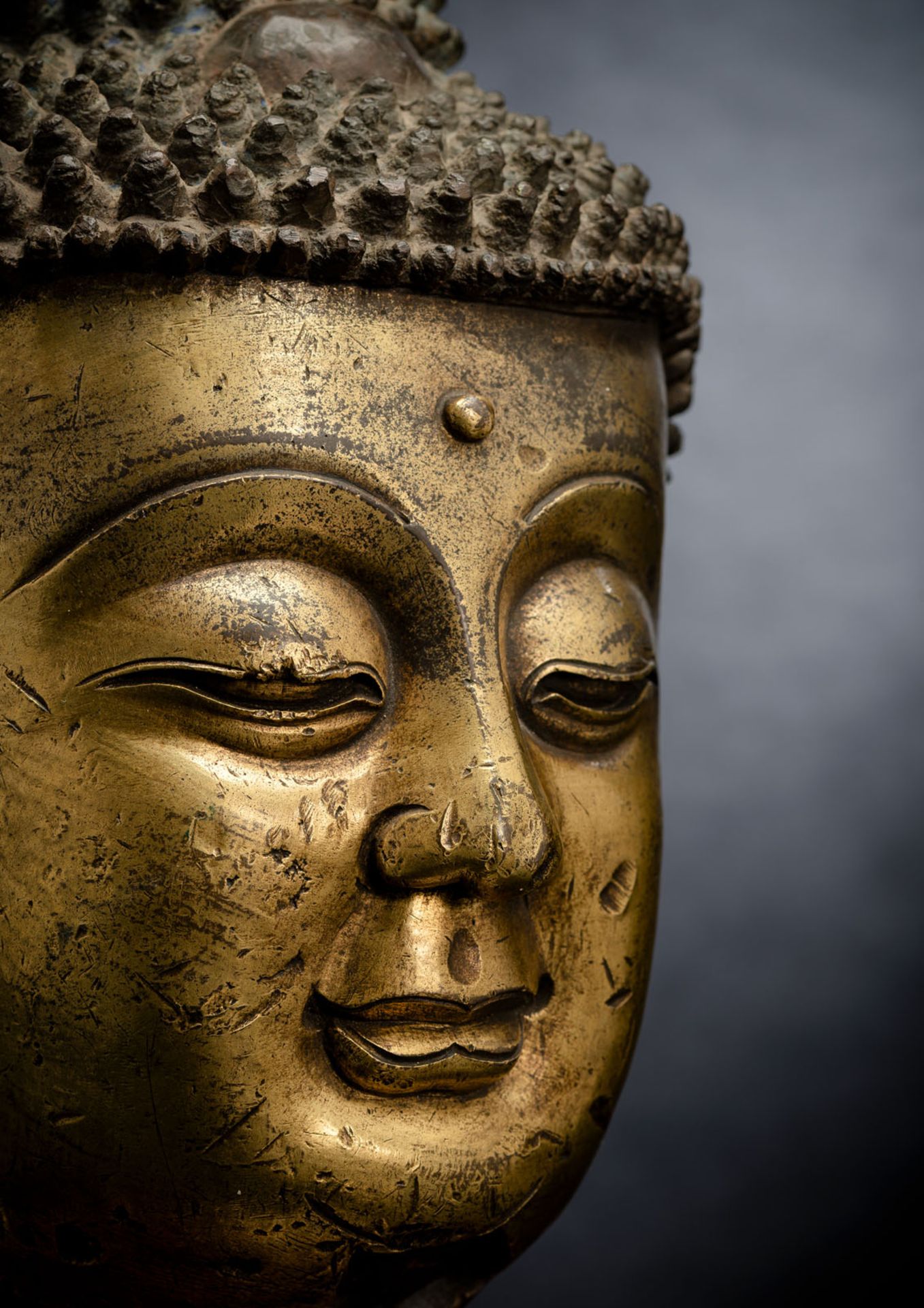 A LARGE GILT-BRONZE HEAD OF BUDDHA ON A WOOD STAND - Image 3 of 13