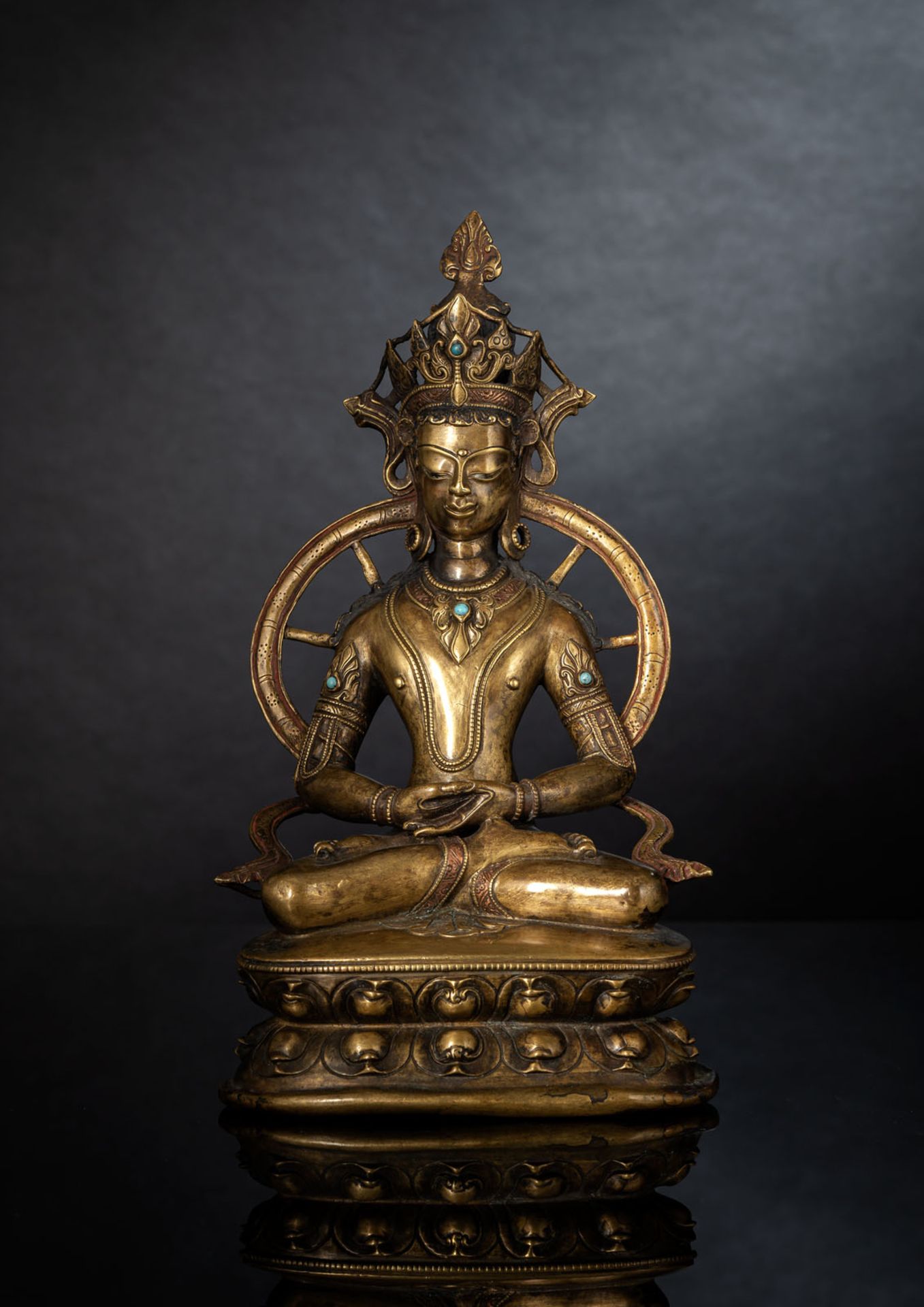 A FINE SILVER- AND COPPER-INLAID BRONZE FIGURE OF AMITABHA