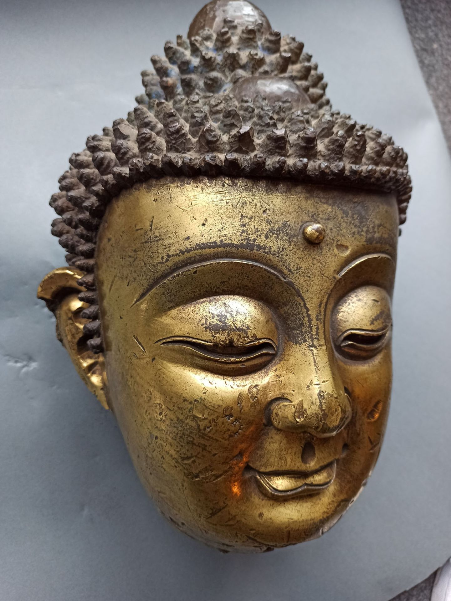 A LARGE GILT-BRONZE HEAD OF BUDDHA ON A WOOD STAND - Image 11 of 13