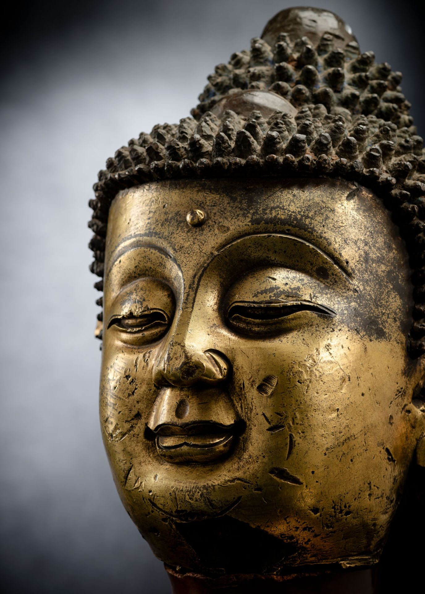 A LARGE GILT-BRONZE HEAD OF BUDDHA ON A WOOD STAND - Image 5 of 13