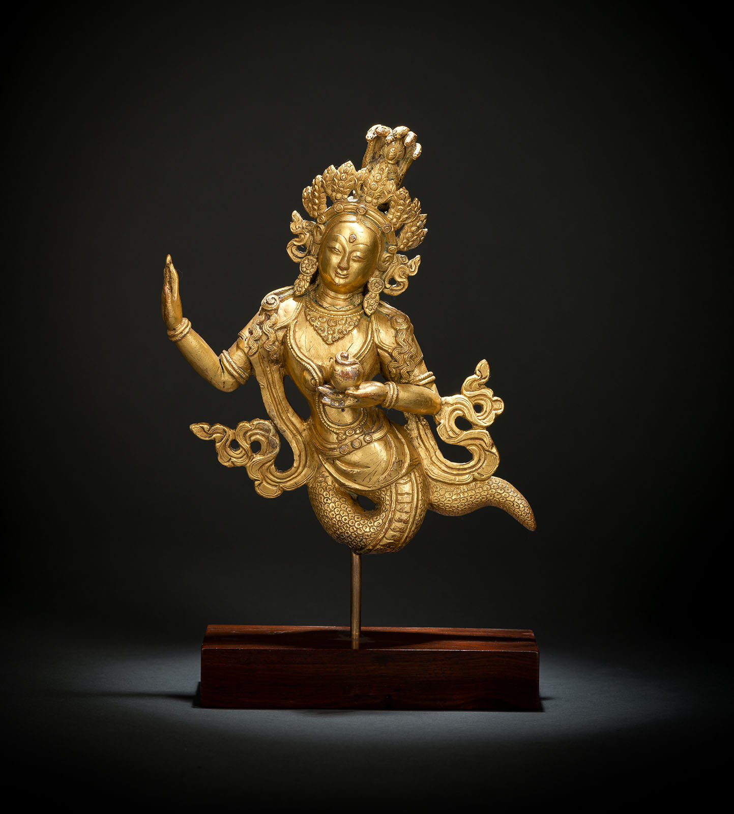 A RARE GILT-BRONZE FIGURE OF NAGANI MOUNTED ON A STAND