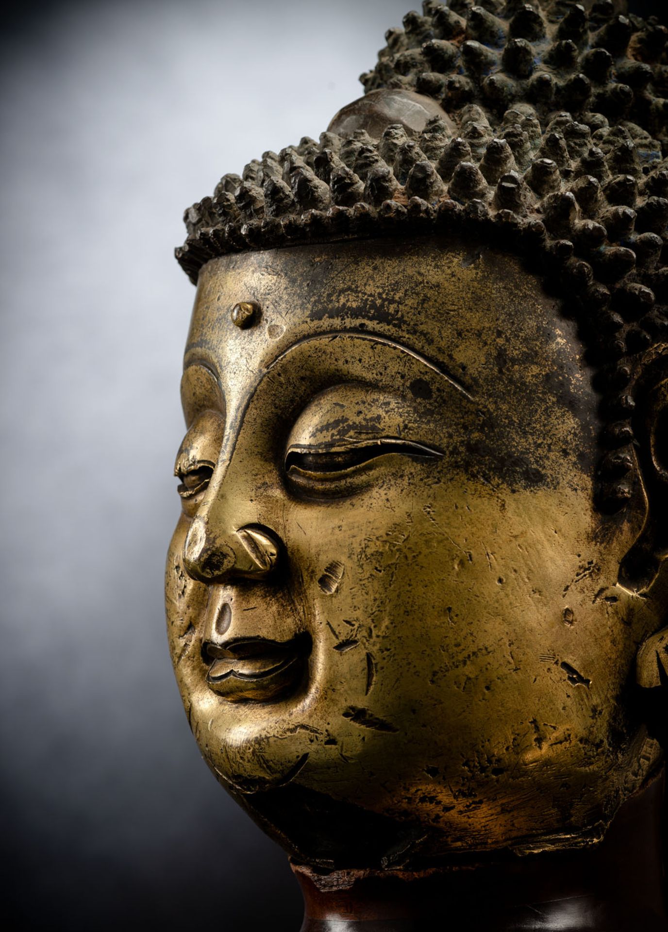 A LARGE GILT-BRONZE HEAD OF BUDDHA ON A WOOD STAND - Image 4 of 13