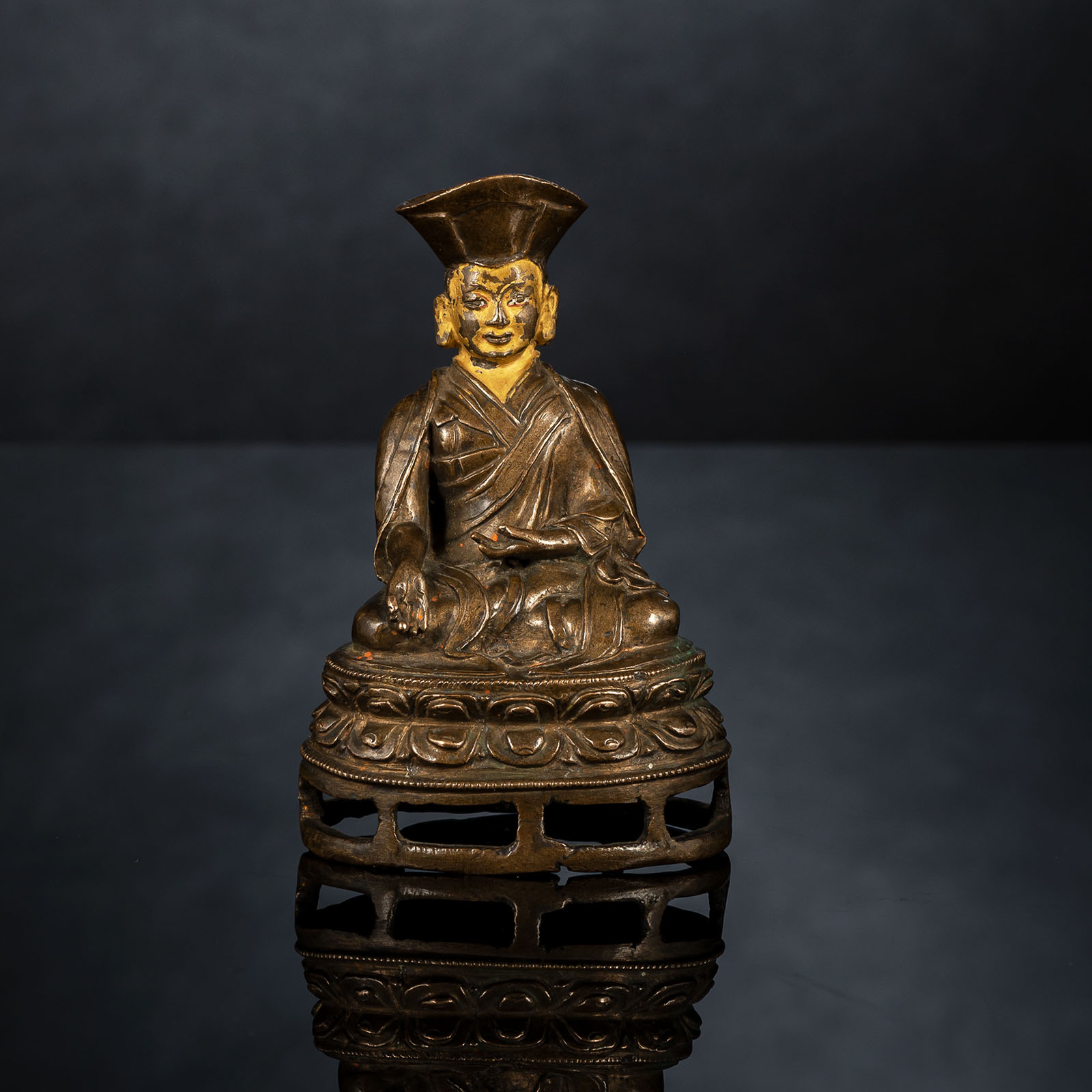 A BRONZE FIGURE OF A LAMA