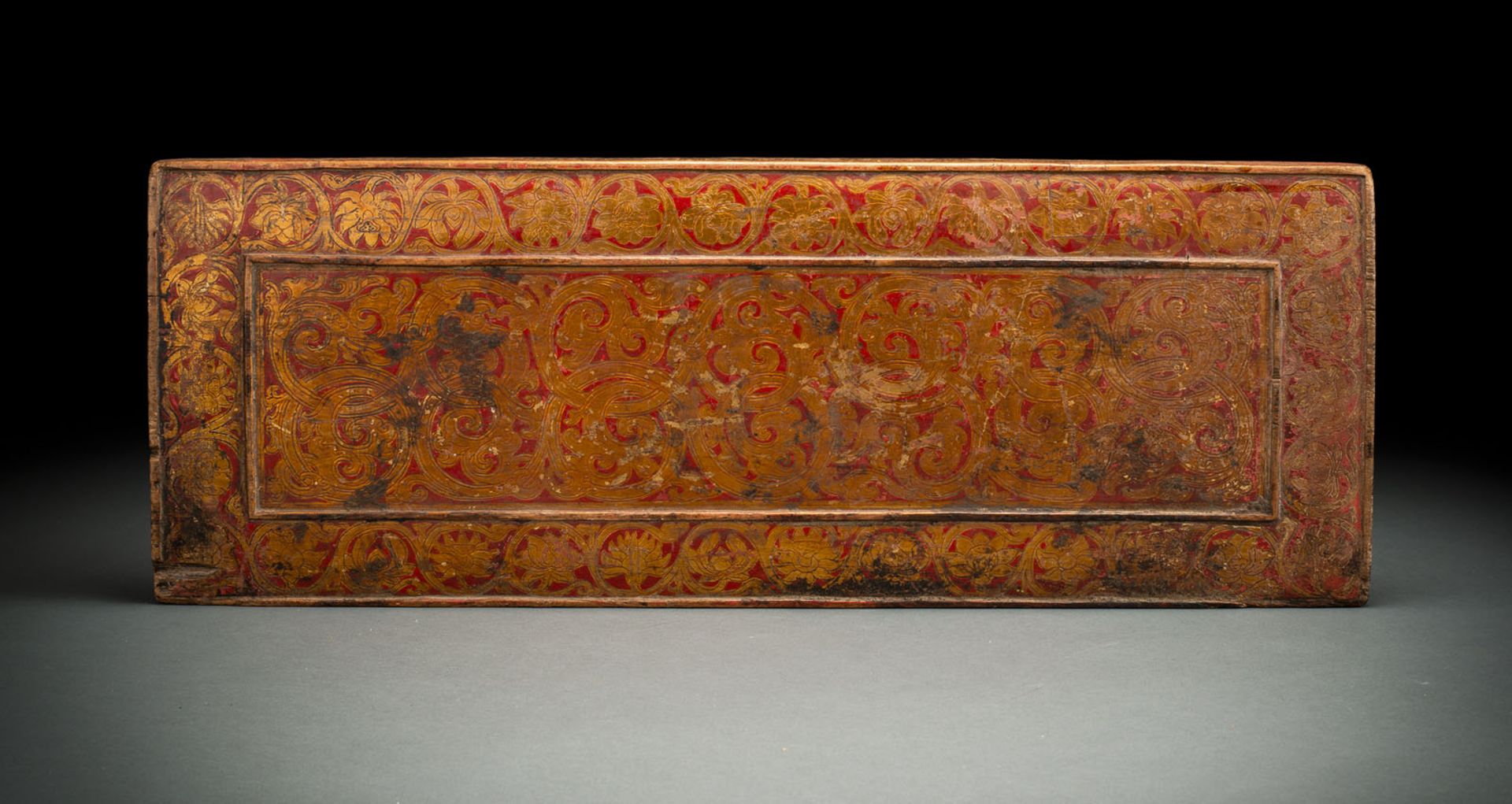 A  GILT AND POLYCHROME MANUSCRIPT COVER FROM WOOD WITH TENDRILS AND FLOWERS