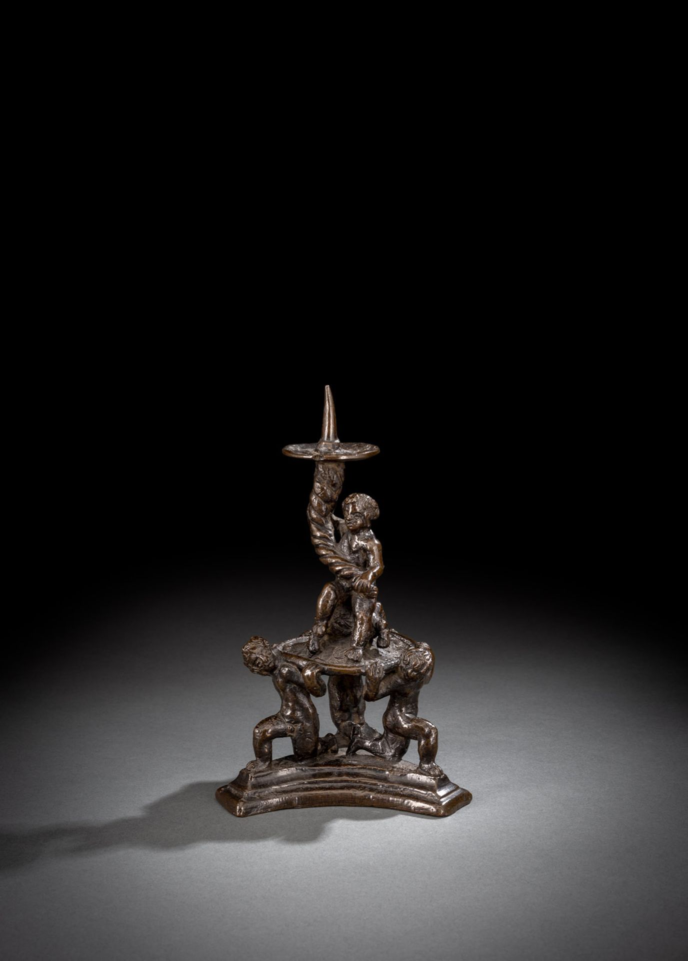 A RENAISSANCE BRONZE CANDLESTICK WITH PUTTI