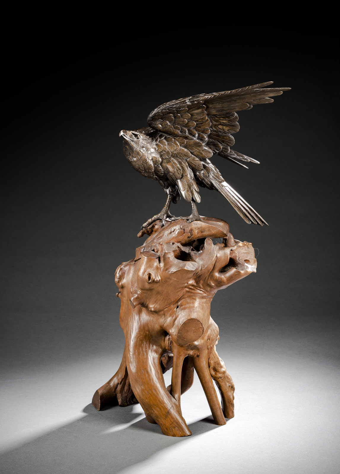 A BRONZE MODEL OF AN EAGLE ON A ROOTWOOD STAND