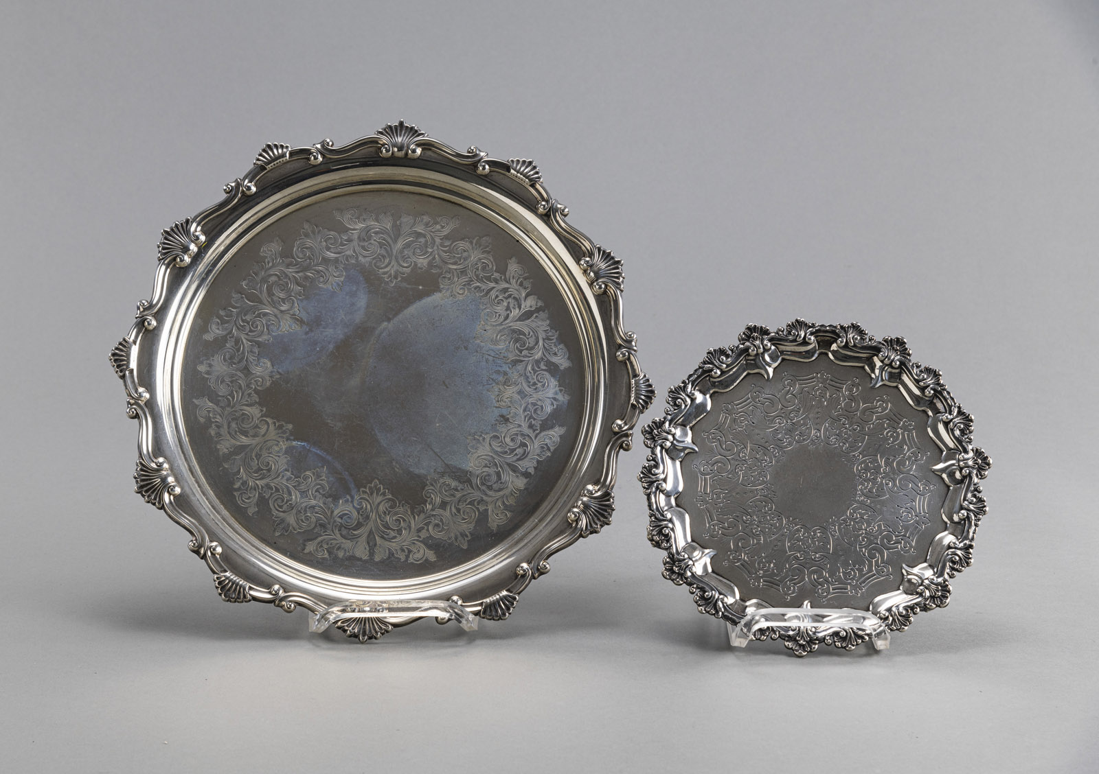 TWO FLORAL TOOLED FOOTED SILVER TRAYS