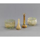 Vier antike Glasgefäße aus grünlichem Glas, teils versintert. Darunter zwei Balsamarien und zwei kl
