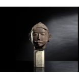 Kopf einer männlichen Gottheit aus rötlich-braunem Stein auf einen Sockel montiert