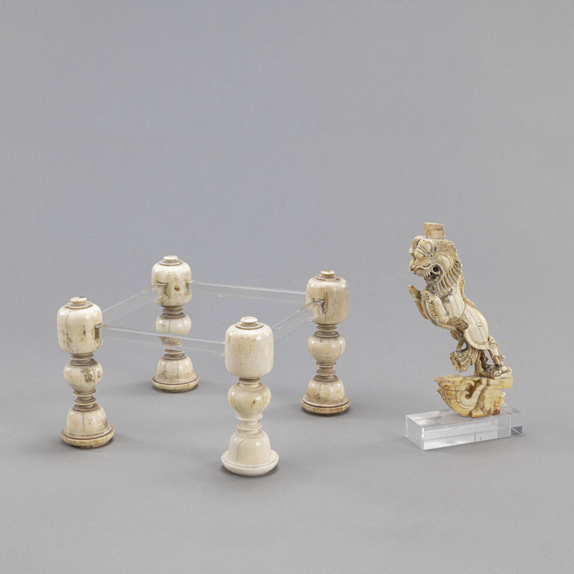 FOUR IVORY THRONE-LEGS AND AN IVORY FIGURE OF A VYALAKA