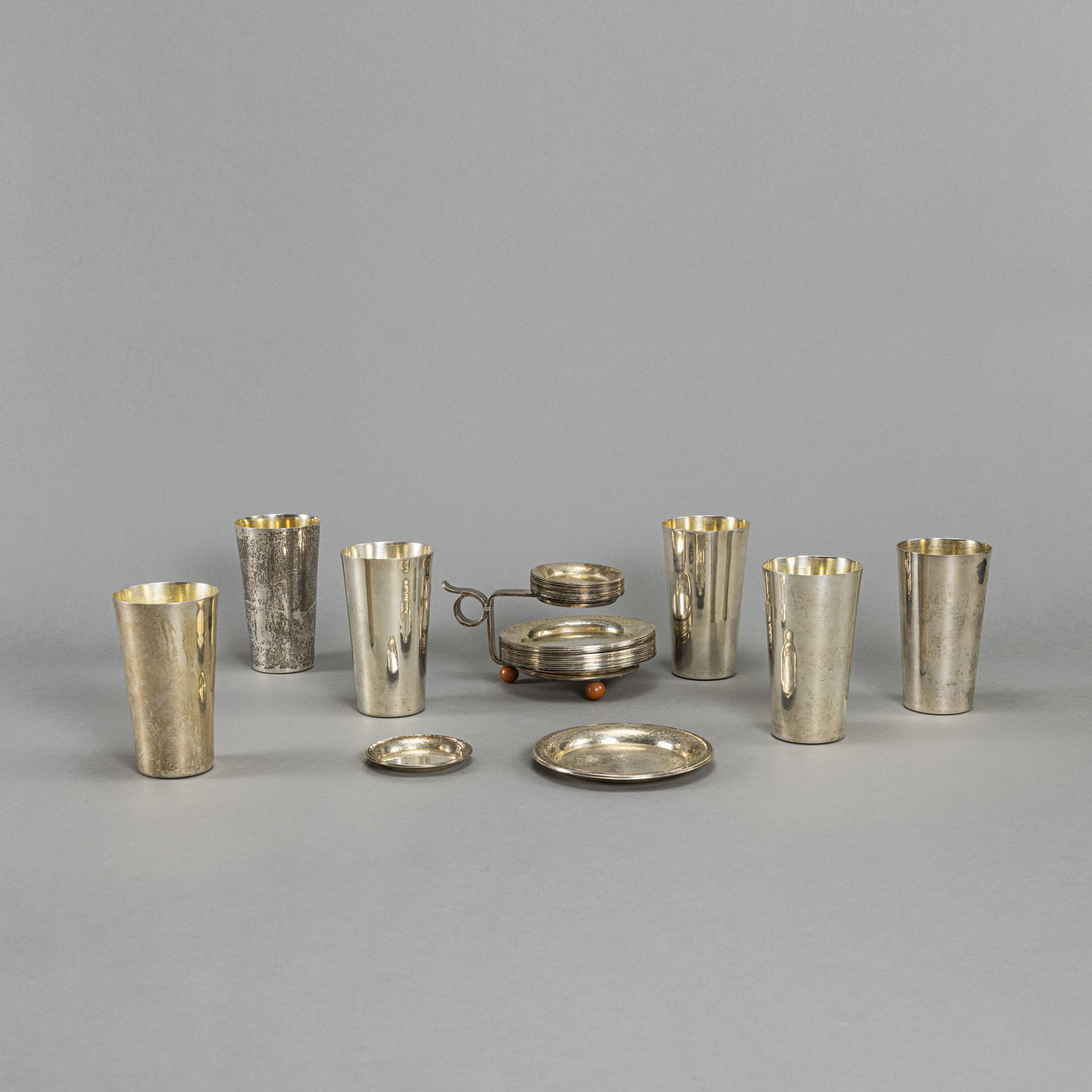 SIX SILVER BEAKER AND A STAND WITH COASTERS