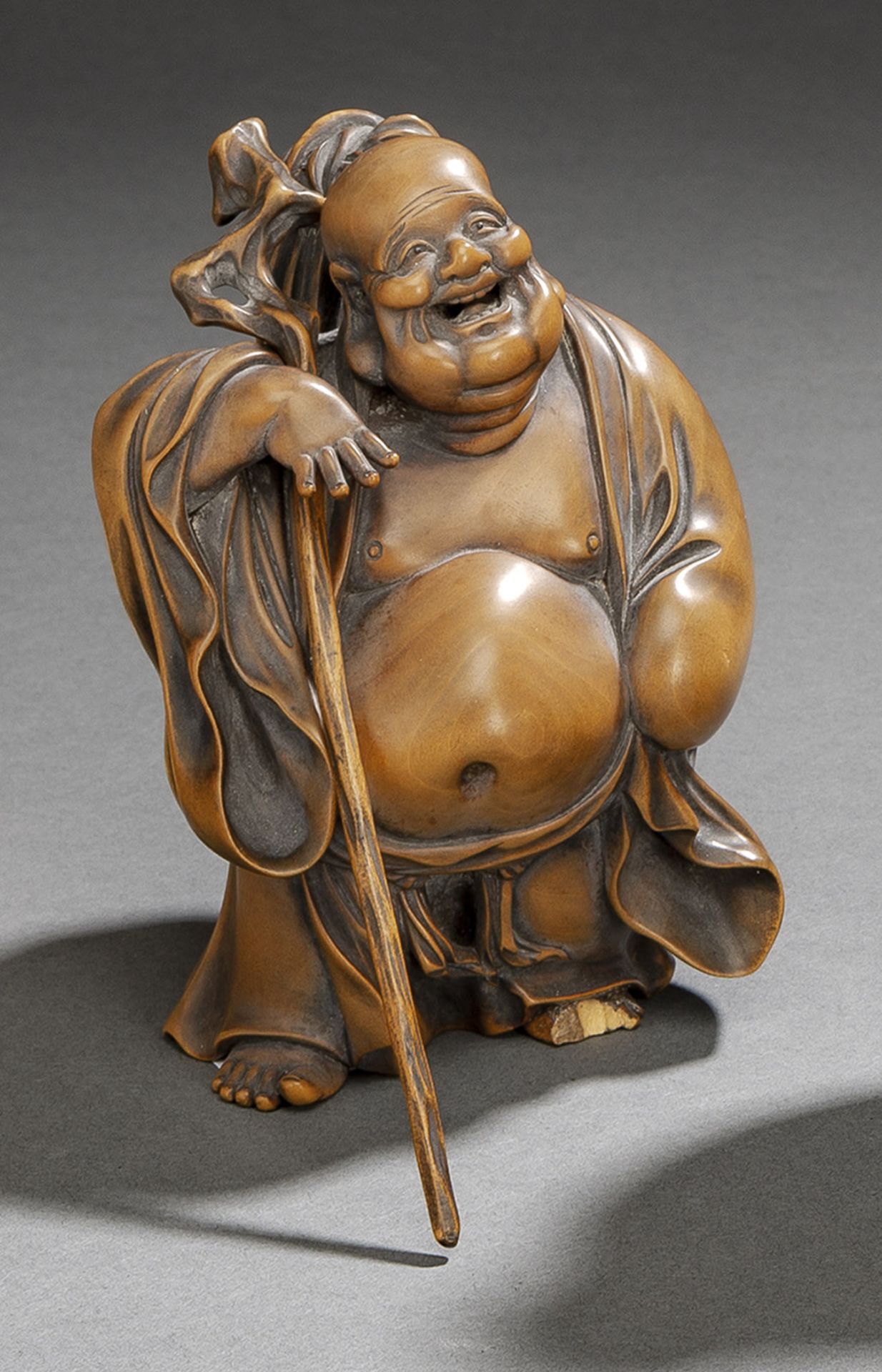 Okimono des Hotei aus Buchsbaum stehend dargestellt mit knorrigem Wanderstab