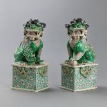 Paar Fo-Hunde mit famille verte-Dekor auf einem hohen Sockel mit ruyi-Relief