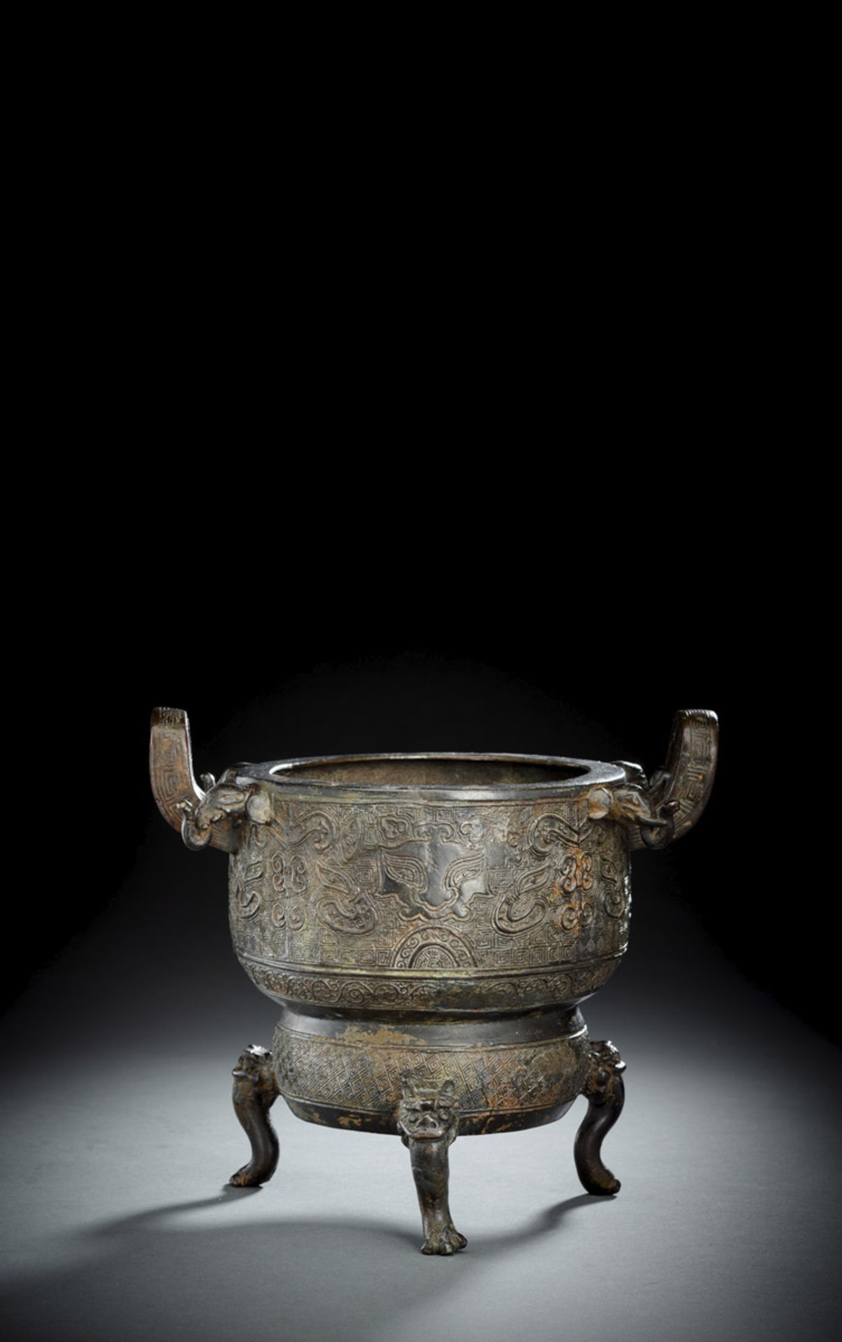 A BRONZE TRIPOD CENSER IN ARCHAIC STYLE WITH TAOTIE AND ELEPHANT HANDLES