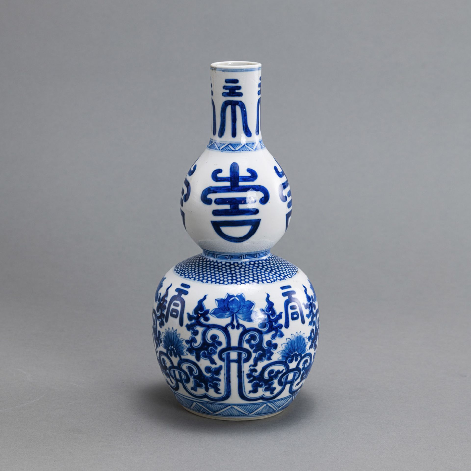 A BLUE AND WHITE DOUBLE-GOURD PORCELAIN LOTUS AND 'SHOU' VASE