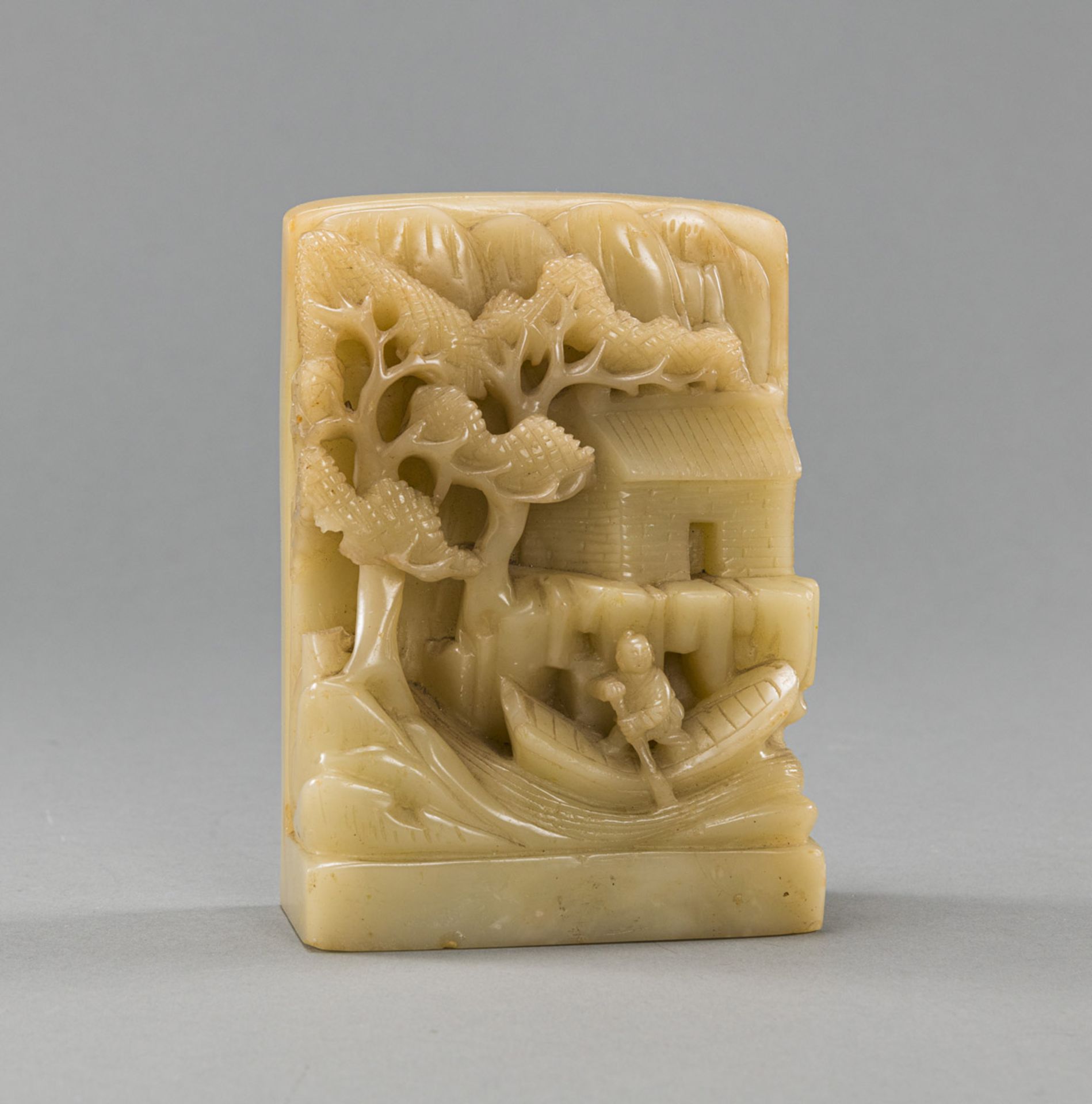 A JADE CARVING DEPICTING A FISHERMAN WITH HOUSE AND PINE TREE
