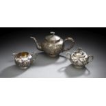 Teekanne aus Metall, Milchkännchen und Zuckerdose aus Silber mit Kranich-Kiefer-Dekor bzw. Blütenz
