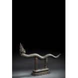 Naga aus Bronze auf einem Stand
