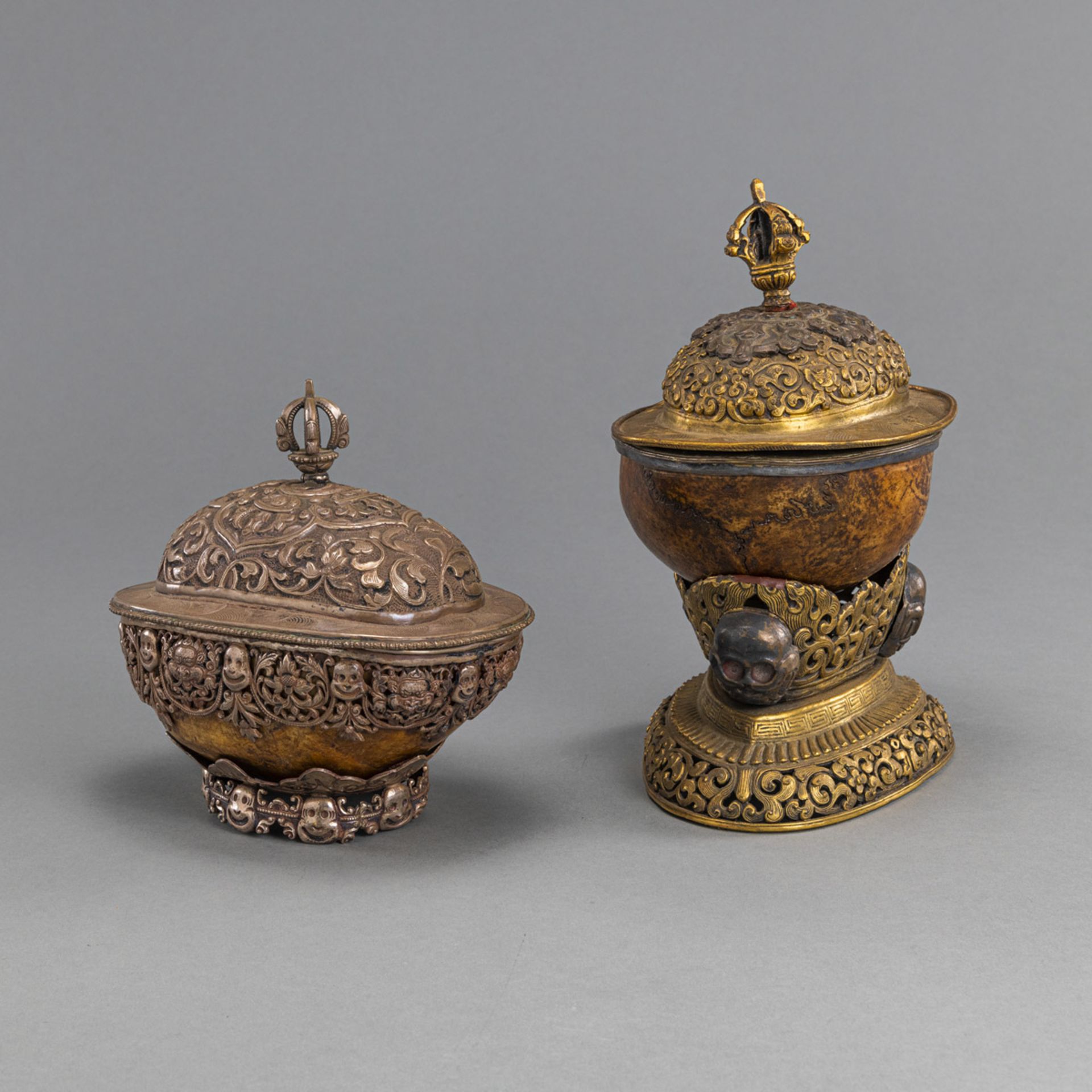 TWO MOUNTED KAPALA, PARTLY WORKED IN SILVER OR GILT-COPPER ON STANDS