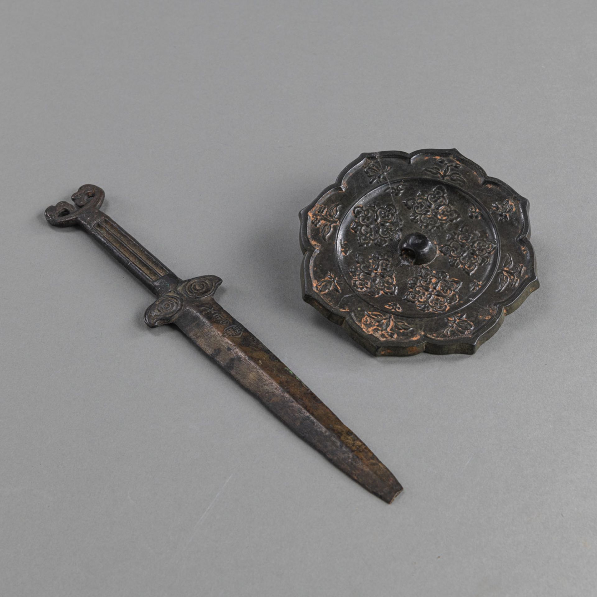 AN EIGHT-LOBED FLORAL BRONZE MIRROR AND A BRONZE DAGGER