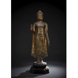 Bronze des stehenden Buddha mit Resten von Vergoldung auf einen Holzsockel montiert