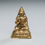 Vergoldete Repoussé-Figur eines sitzenden Lama