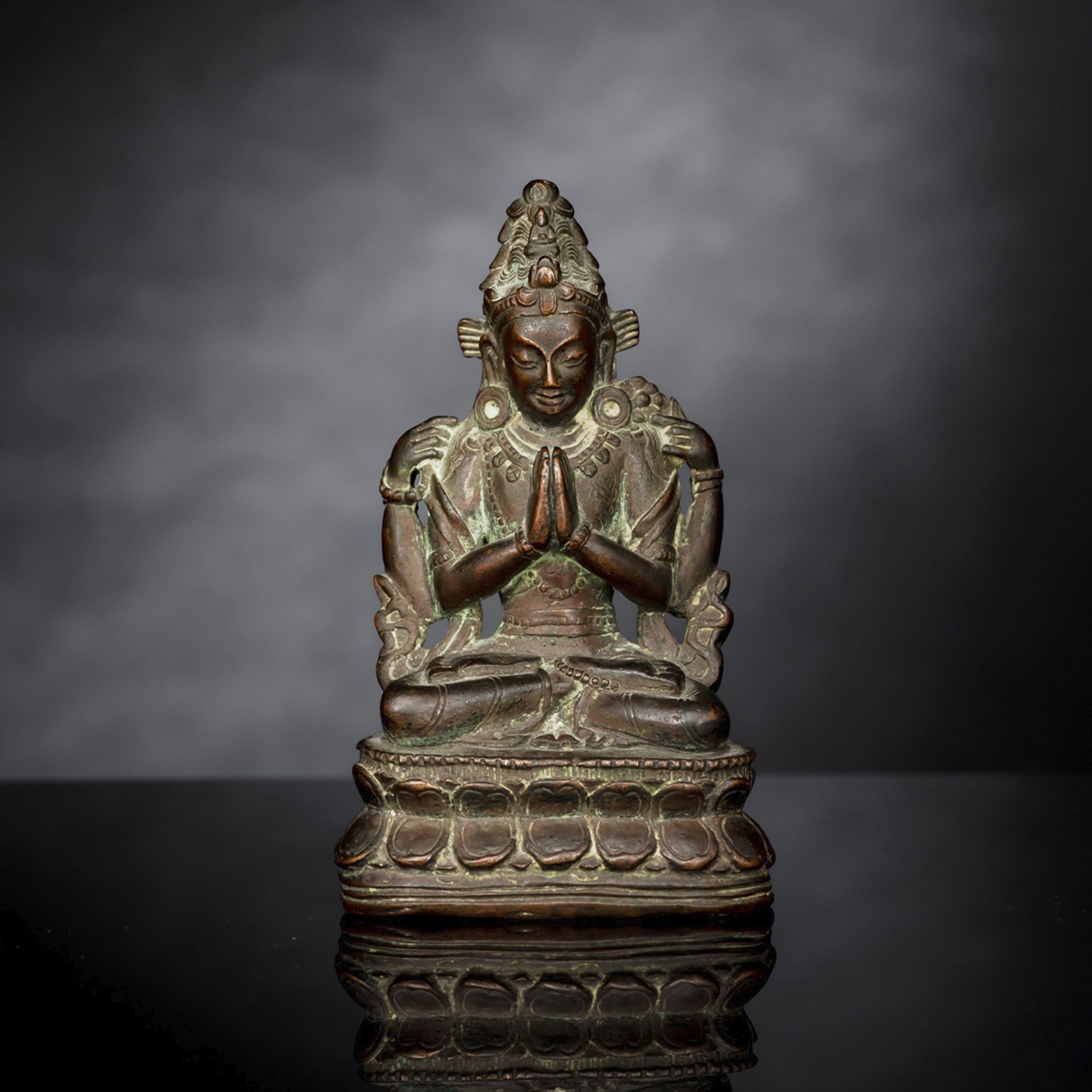 A BRONZE FIGURE OF SADAKSHARILOKESHVARA SEATED ON A LOTUS