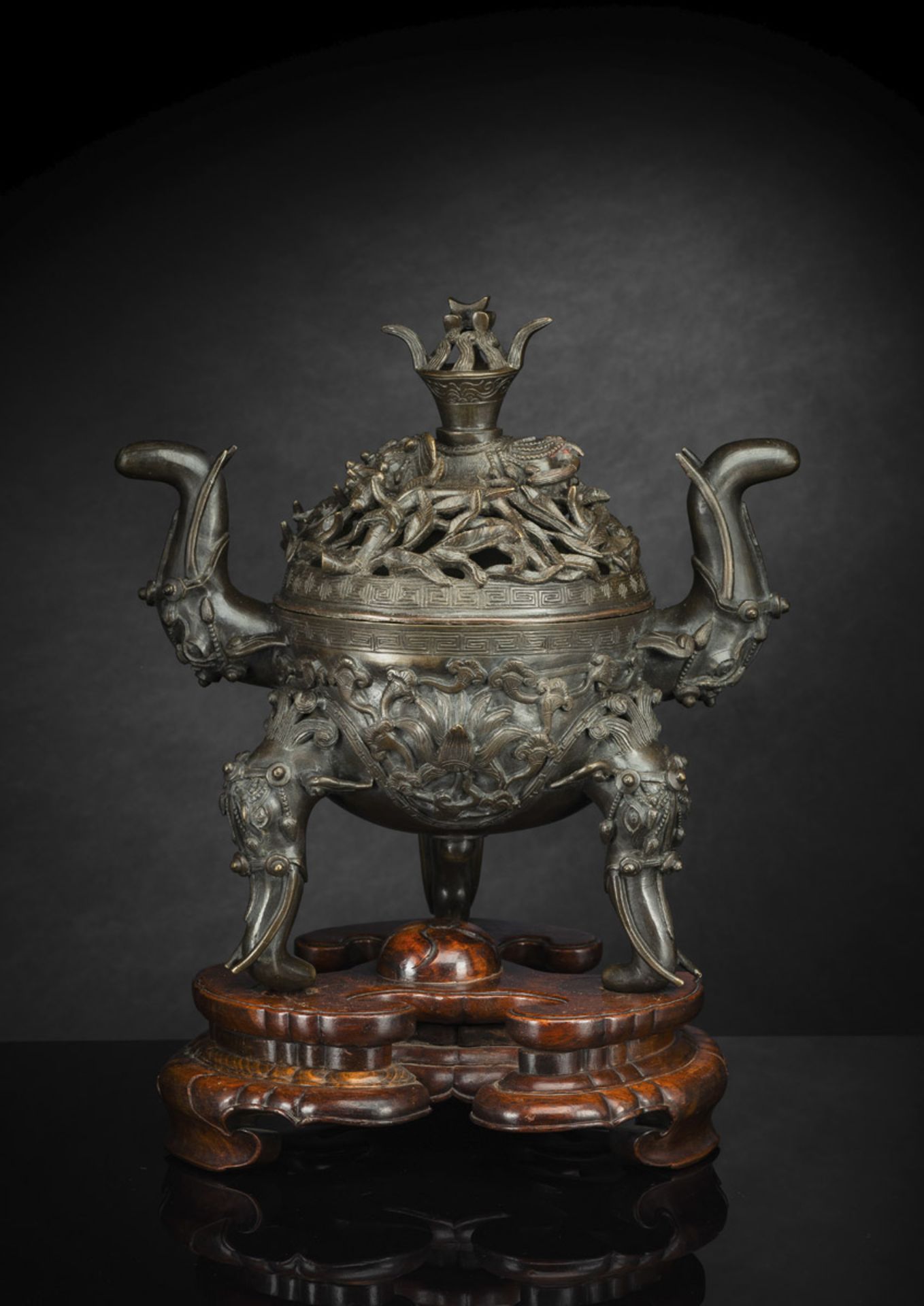 A BRONZE ELEPHANT AND LOTUS TRIPOD CENSER ON WOOD STAND