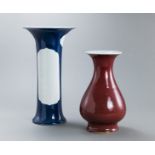 Stangenvase mit puderblauer Glasur und leeren Kartuschen und eine Vase mit kupferroter Glasur