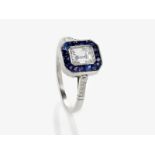 Art Dèco Entouragering mit einem Diamant im Emerald Cut und Saphiren