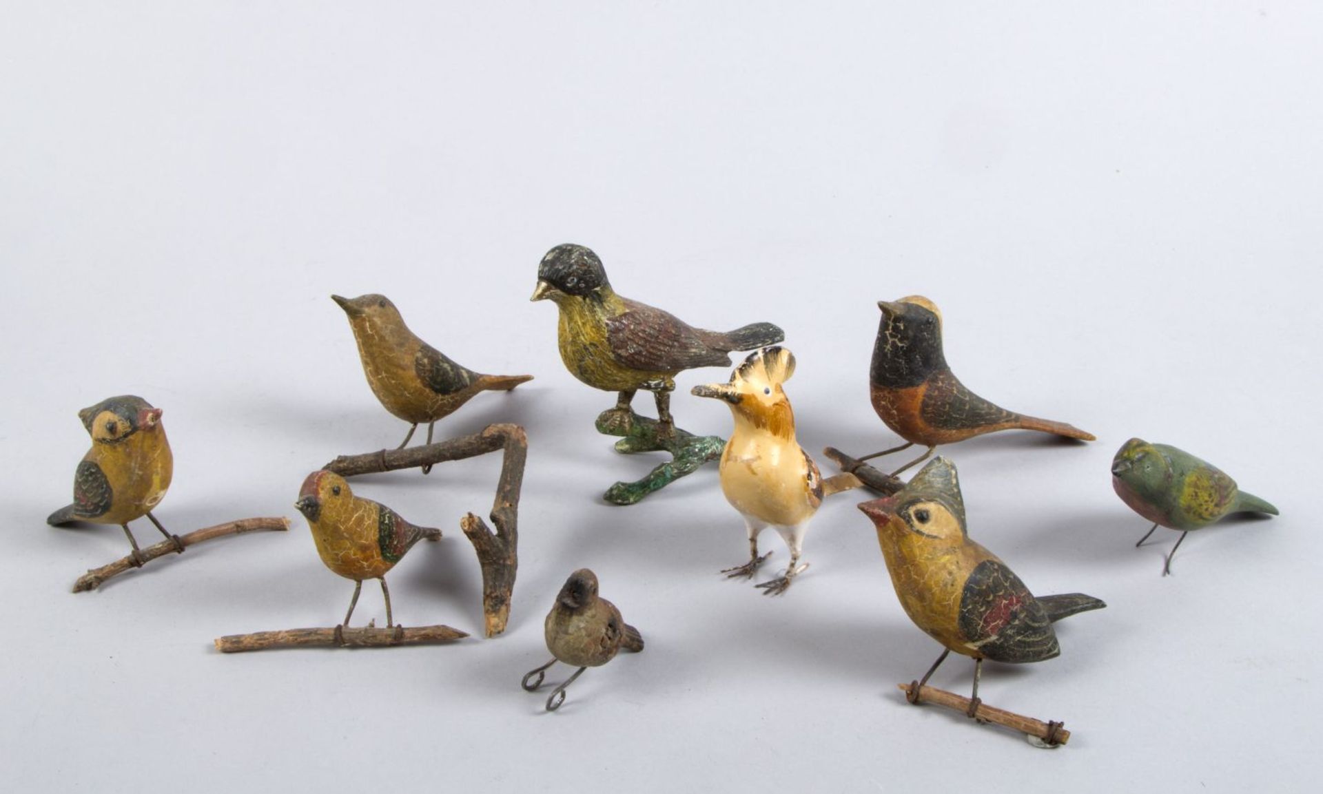 Neun kleine Vögel Holz, geschnitzt und Metall. Polychrome Bemalung. Tlw. auf Holzast montier
