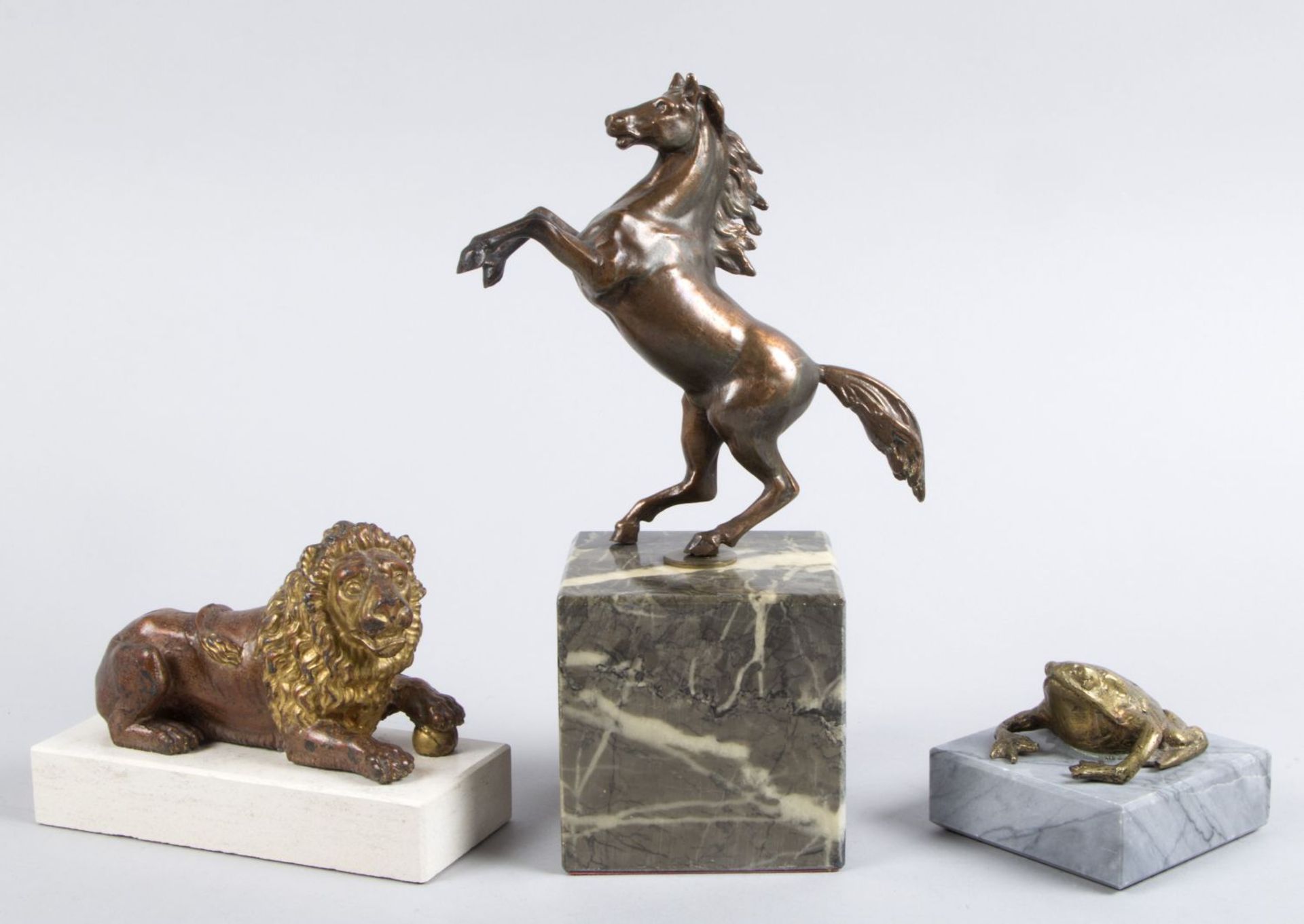 Unbekannt, 20. Jh. Steigendes Pferd. Löwe. Kröte. 3 Metallskulpturen. H. bis 13 cm. Auf Steinsockel.