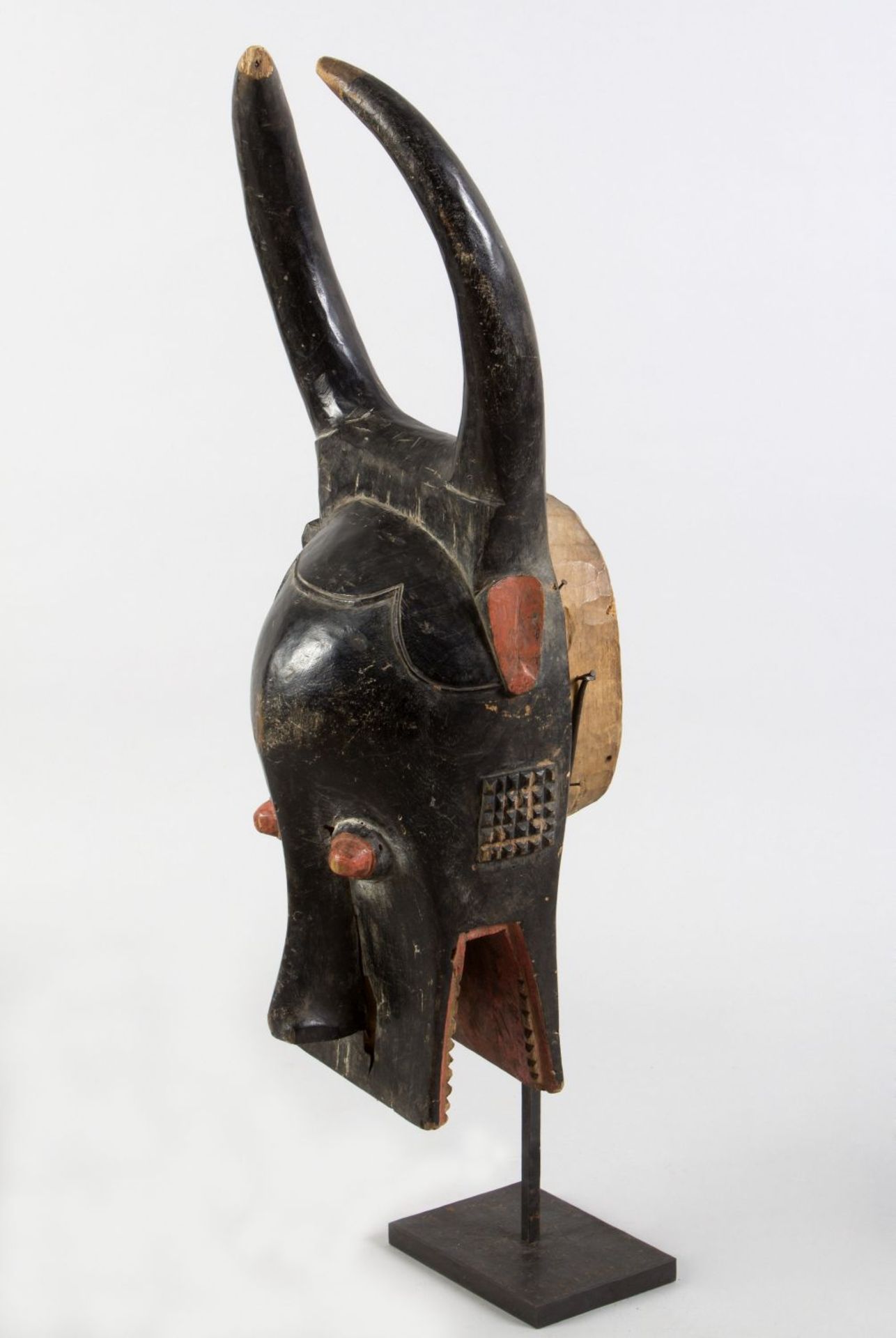 Maske Holz, geschnitzt. Schwarz und rot bemalt. In Form eines Tierkopfes mit Hörnern. Afrika. H. 78  - Bild 2 aus 2