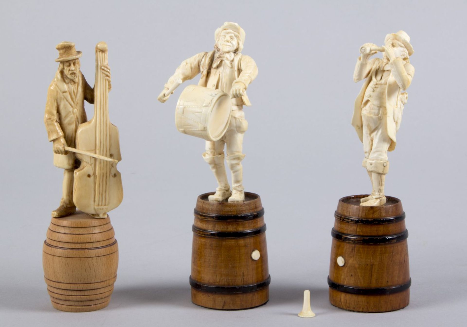 Drei Musiker-Miniaturfiguren Elfenbein, geschnitzt. Vollplastische Standfiguren mit Cello, Trompete 