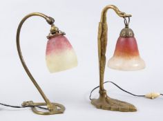 Zwei Tischlampen Messingfuß. 1-flammig. Glocken aus Überfangglas mit farbigen Pulvereinschmelzungen.