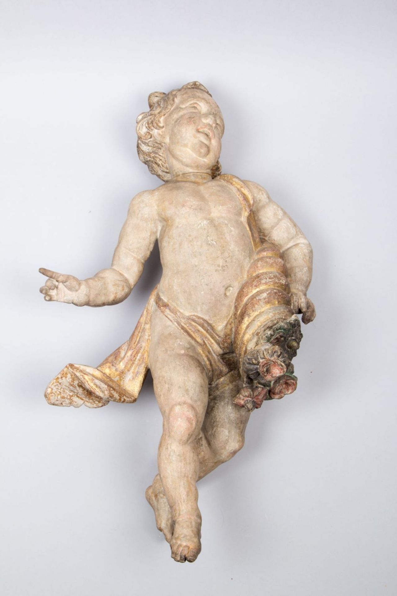 Putto Holz, geschnitzt. Vollrunde Ausführung. Farb- und Goldfassung. Mit Füllhorn. Südd., 18. Jh. H.